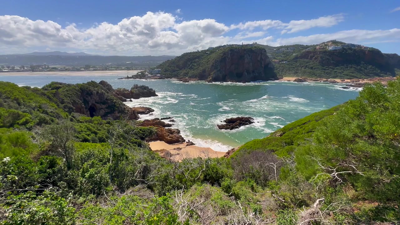Paesaggio costiero della laguna di Knysna con scogliere rocciose e acque blu in Sudafrica.