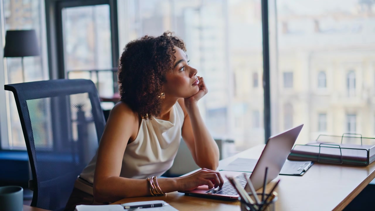 Businesswoman thinking at desk looking away. Pensive entrepreneur planning work