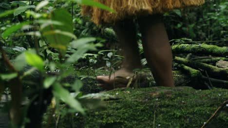 footsteps of indigenous guy walking along a path in the dense forest in leticia, amazon, colombia