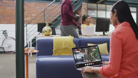 Biracial-woman-using-laptop-for-video-call,-with-business-colleague-on-screen