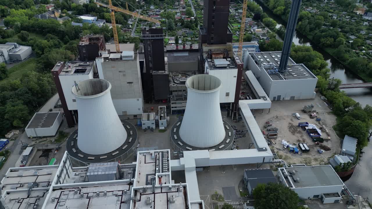 2 crane dismantling a power plant during a demolition process. Amazing aerial view flight fly reverse drone