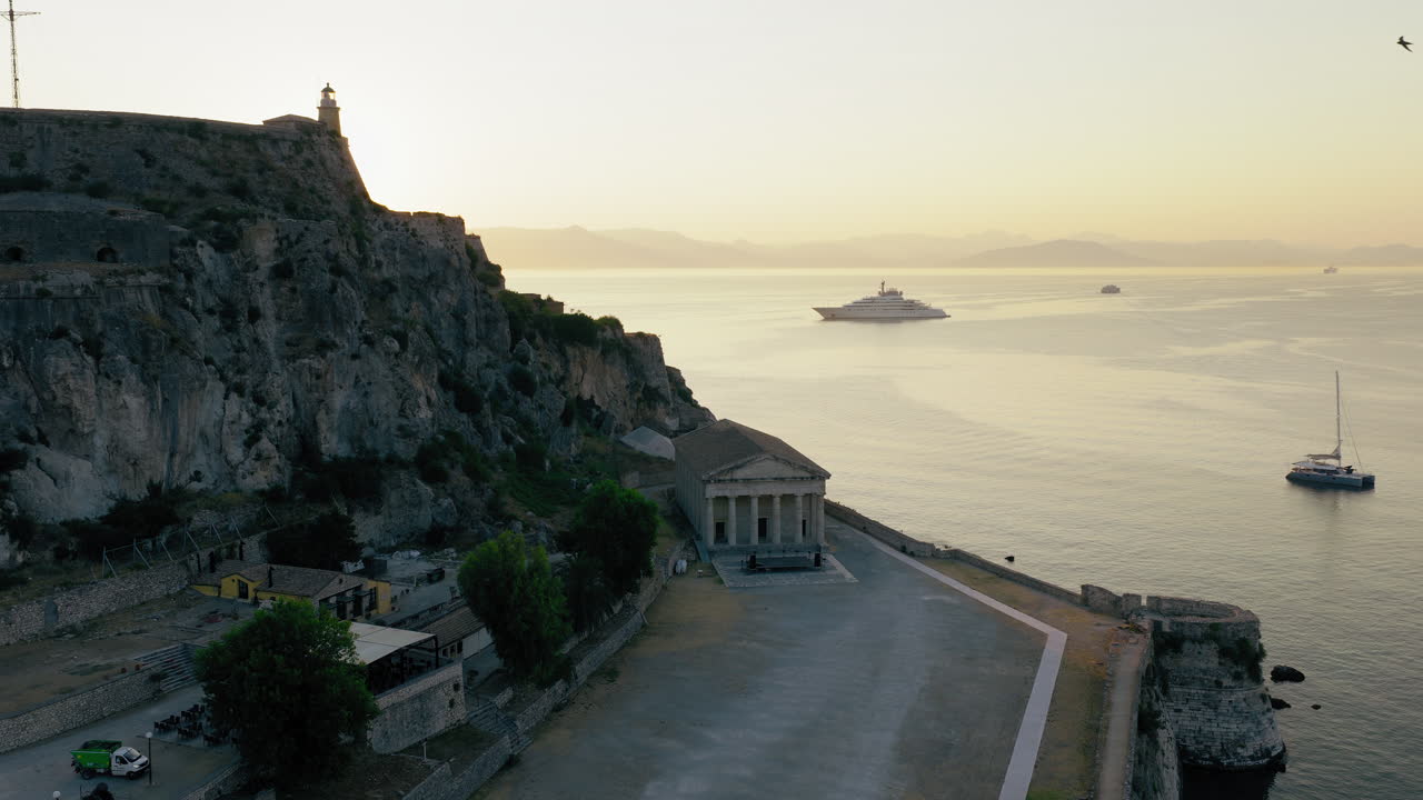 Greek orthodox church of Saint George inside Old Fortress of Corfu at sunrise, Corfu Town, Cruise and yachts on Ionian sea, Drone shot