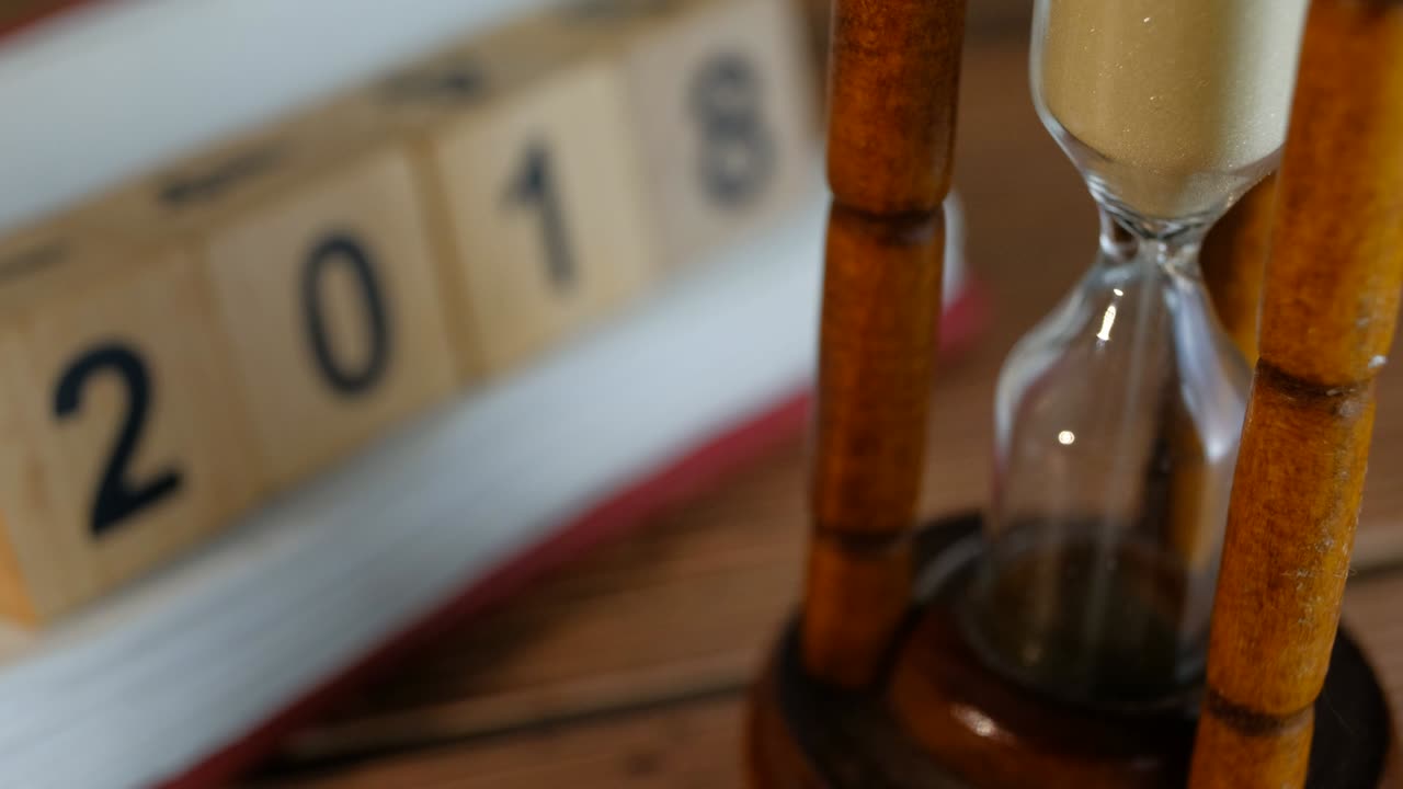 Primo piano di sabbia in clessidra per il conto alla rovescia del tempo 2018. Per ciclo o pattern ripetuto