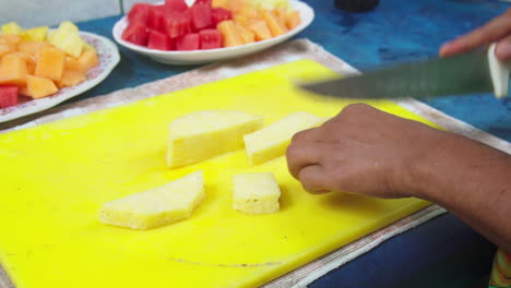 Close-up-of-a-knife-cutting-up-pineapple-while-making-fruit-smoothies-in-Punta-Banco,-Costa-Rica