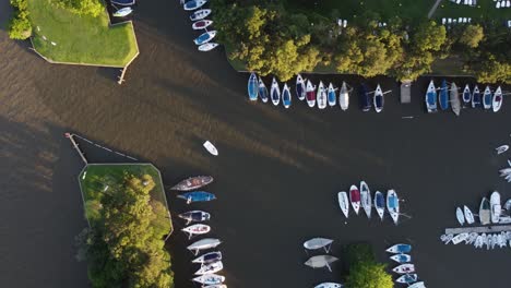 Boats-moored-in-San-Isidro-Yacht-club-along-Rio-de-la-Plata-river-at-sunset,-Buenos-Aires-in-Argentina