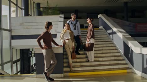 group of people having a conversation on stairs in a modern building