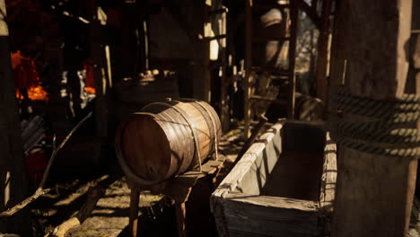 An old wooden barrel and water trough in a rustic workshop during daylight