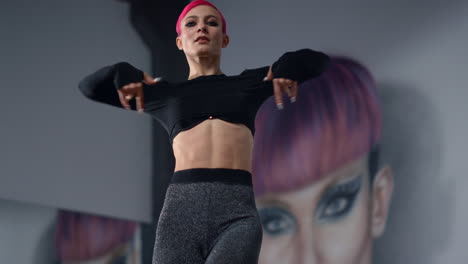 bailarina que busca una cámara bonita en el estudio. mujer de ropa deportiva bailando en una clase moderna