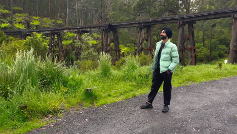 Hombre-Sikhi-Con-Turbante-Negro-Con-Bosque-Y-Puente-Viejo-Al-Fondo