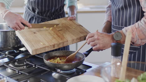 Middle-aged-caucasian-couple-preparing-meal,-cooking-together-in-kitchen-at-home,-slow-motion