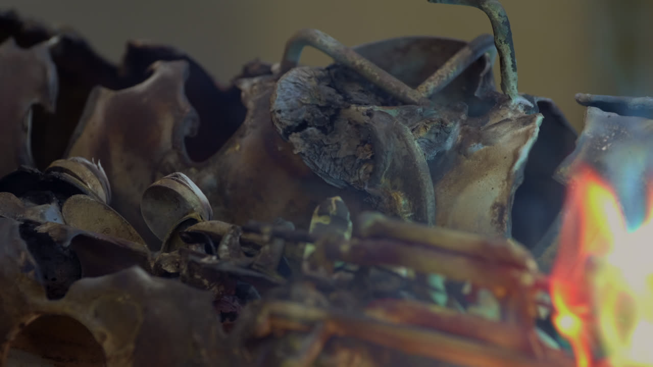 un herrero usa soldadura de gas para derretir un saxofón de latón, lo que genera chispas destructivas y llamas de colores brillantes
