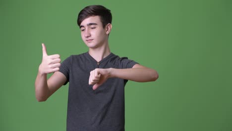 young handsome iranian teenage boy against green background