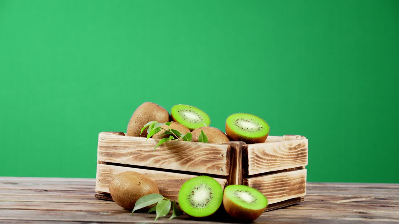 Wooden box with ripe kiwi rotates slowly.