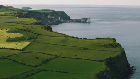 Toma-Aérea-En-Círculos-De-Los-Acantilados-Y-El-Océano-De-Irlanda-Del-Norte.