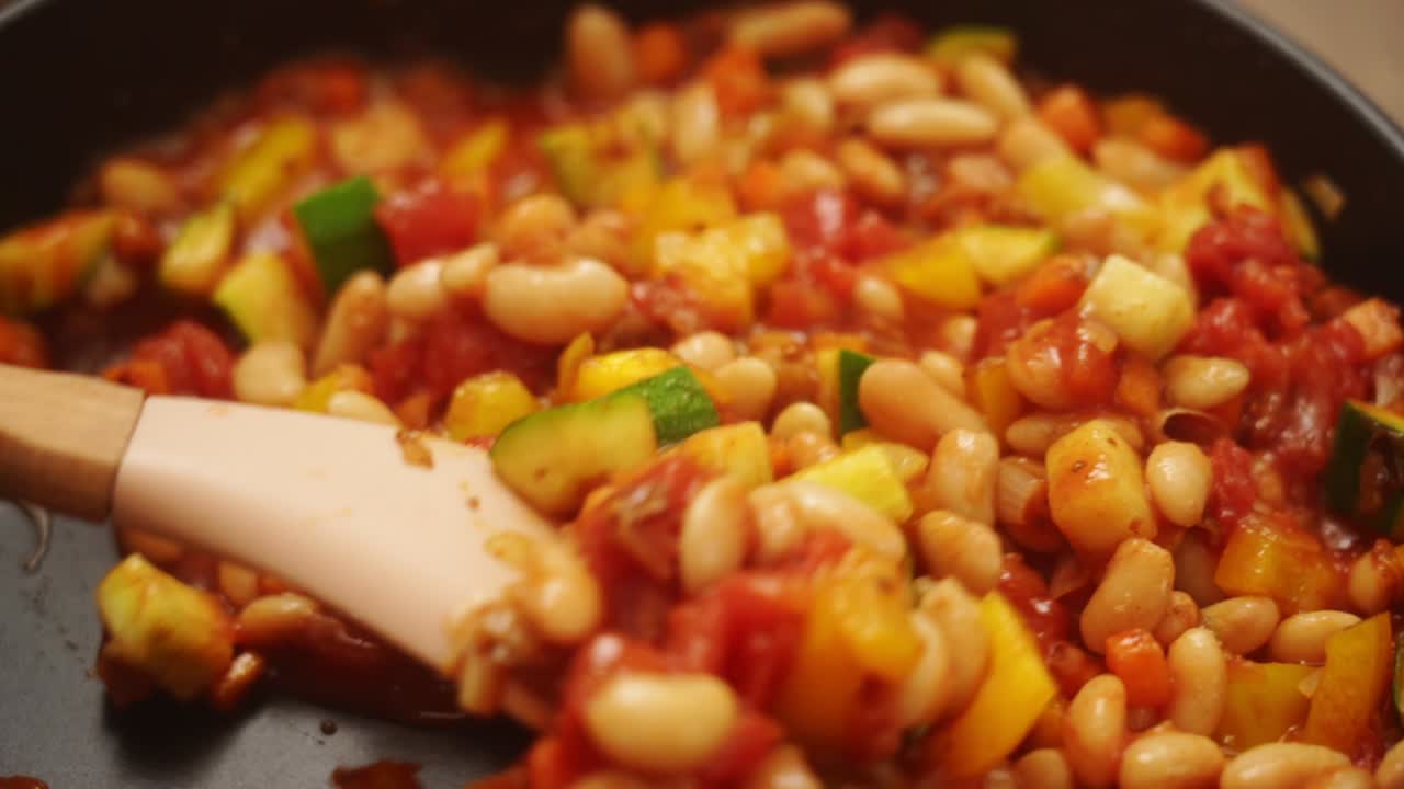 persona anónima preparando un apetitoso gratin de tomate y frijol
