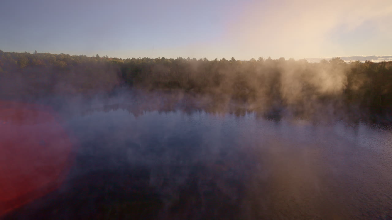 Aerial drone view of mist floating upward from the water at sunrise