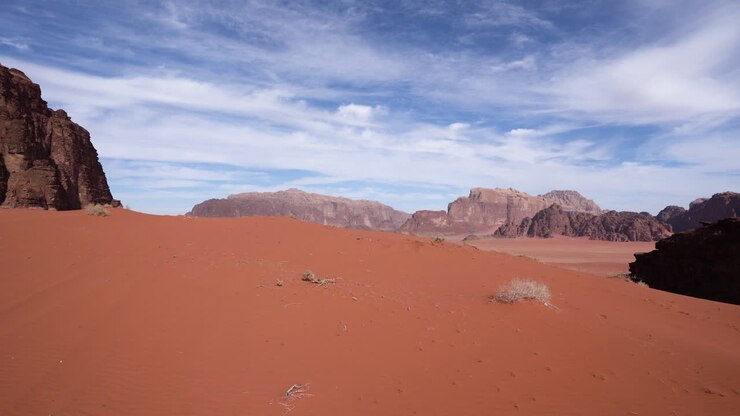 Passeggiata su una duna di sabbia nel deserto del Wadi Rum durante le ore luminose di un giorno di sole.