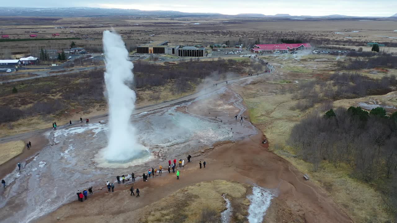 los turistas observan la erupción del géiser strokkur en el valle haukadalur de islandia