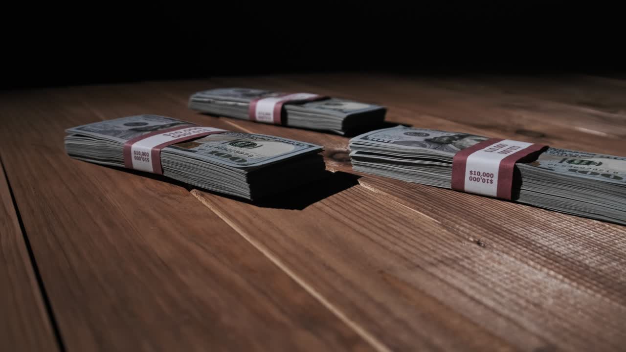 Three Stacks of 10000 American Dollars Banknotes in Bundles Lie on Wooden Table