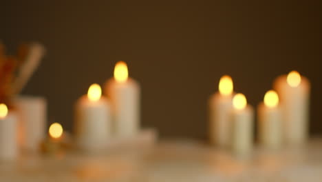 defocused still life shot of lit candles with dried grasses as part of relaxing spa day decor