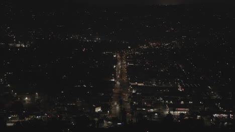 Center-view-of-a-road-with-fireworks-going-off-around-it-at-night