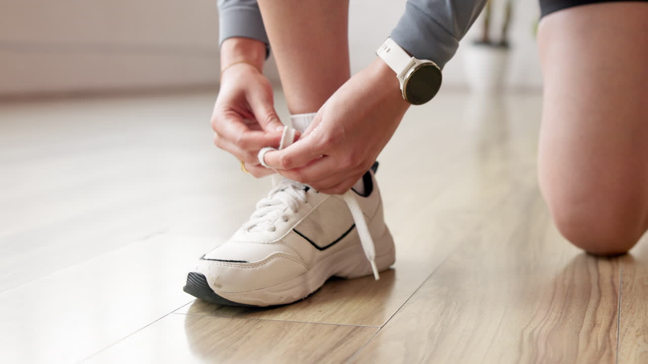 Allacciare le stringhe di scarpe da ginnastica bianche