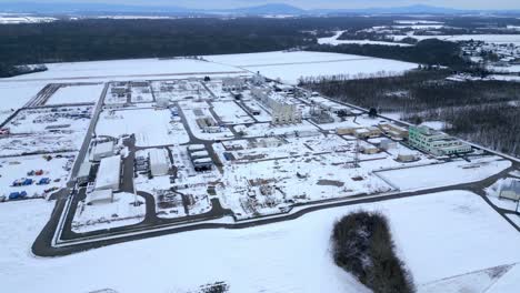 Vista-Aérea-De-La-Estación-De-Compresores-Cubierta-De-Nieve-Durante-El-Invierno-En-Baumgarten,-Austria