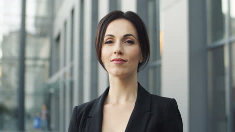 close up view of smiling businesswoman in the street and looking to the camera