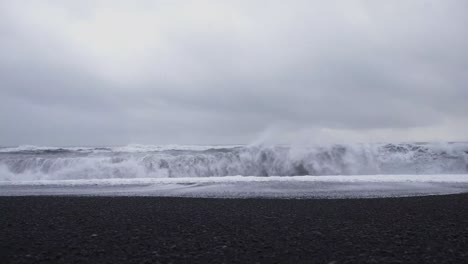 olas de tormenta rompiendo en la playa de arena negra reynisfjara en islandia