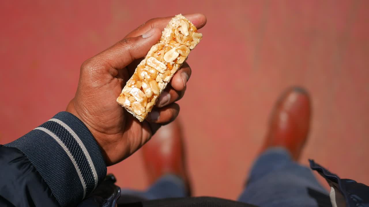 Person holding a peanut brittle (chikki) snack