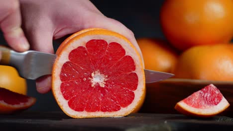 hands men cut the grapefruit into round slices.