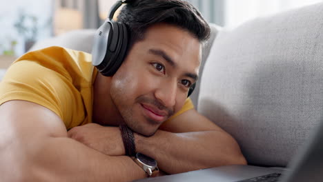 hombre en el sofá con portátil, auriculares