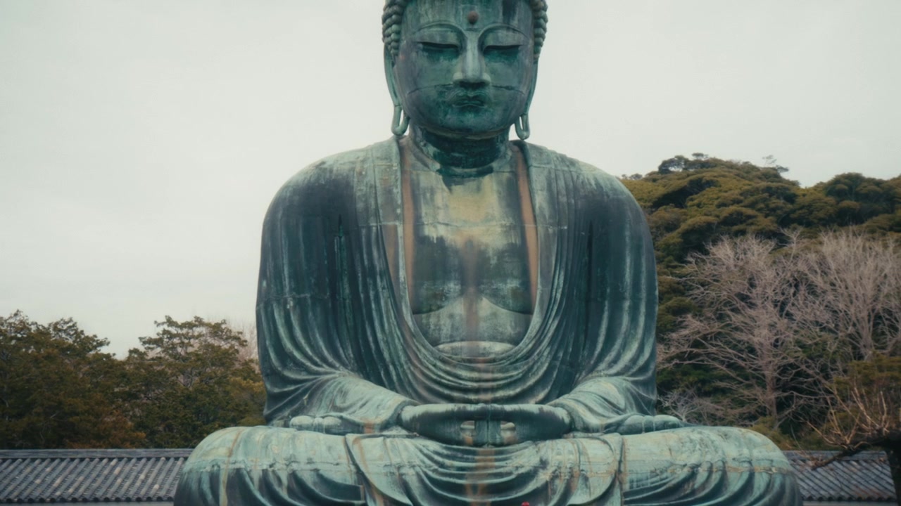 Una suggestiva composizione simmetrica cattura la figura intera del Grande Buddha di Kamakura presso il Tempio Kotoku-in, Giappone, con la sua superficie di bronzo invecchiato e l'espressione calma sullo sfondo di cieli coperti