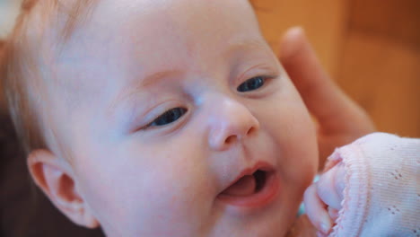 a laughing baby leaning at his mother's feet