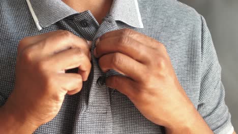 un hombre abotonando su camiseta polo.