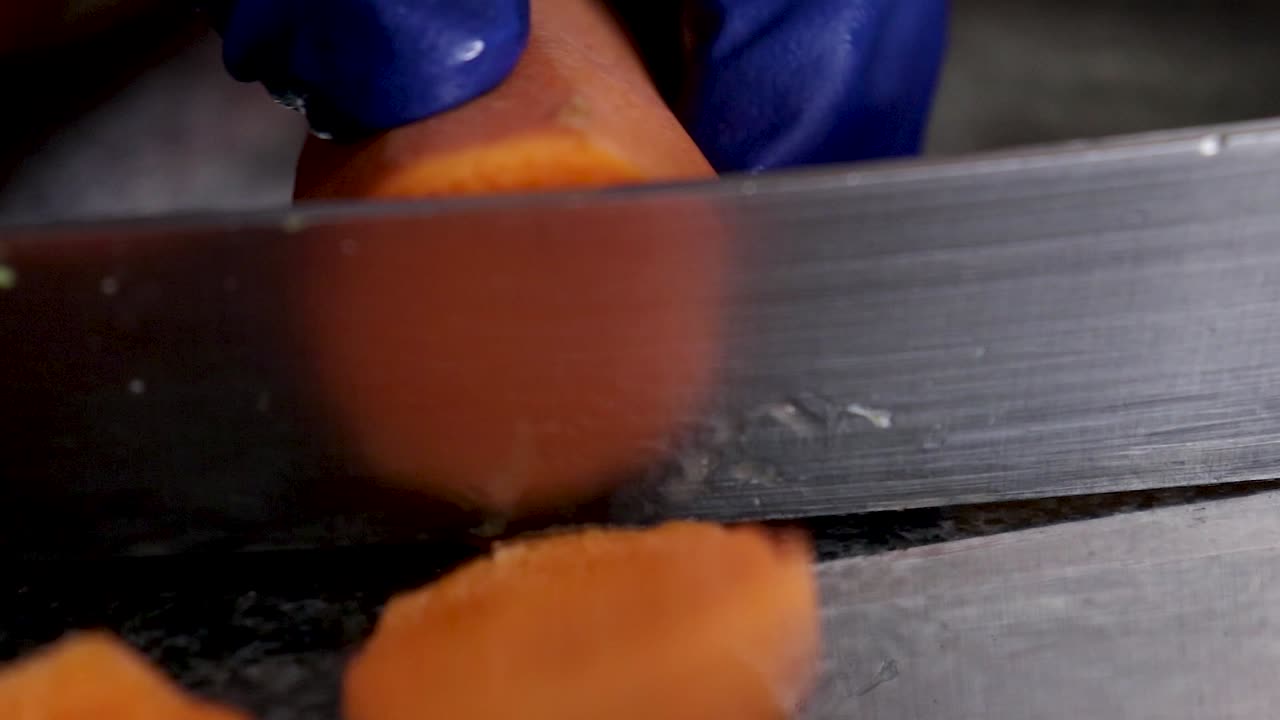 Primo piano di una carota pelata affettata su un piano di marmo.