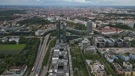 sentado en la plaza en el medio de la escena, oficinas de diseño resaltan torres, múnich