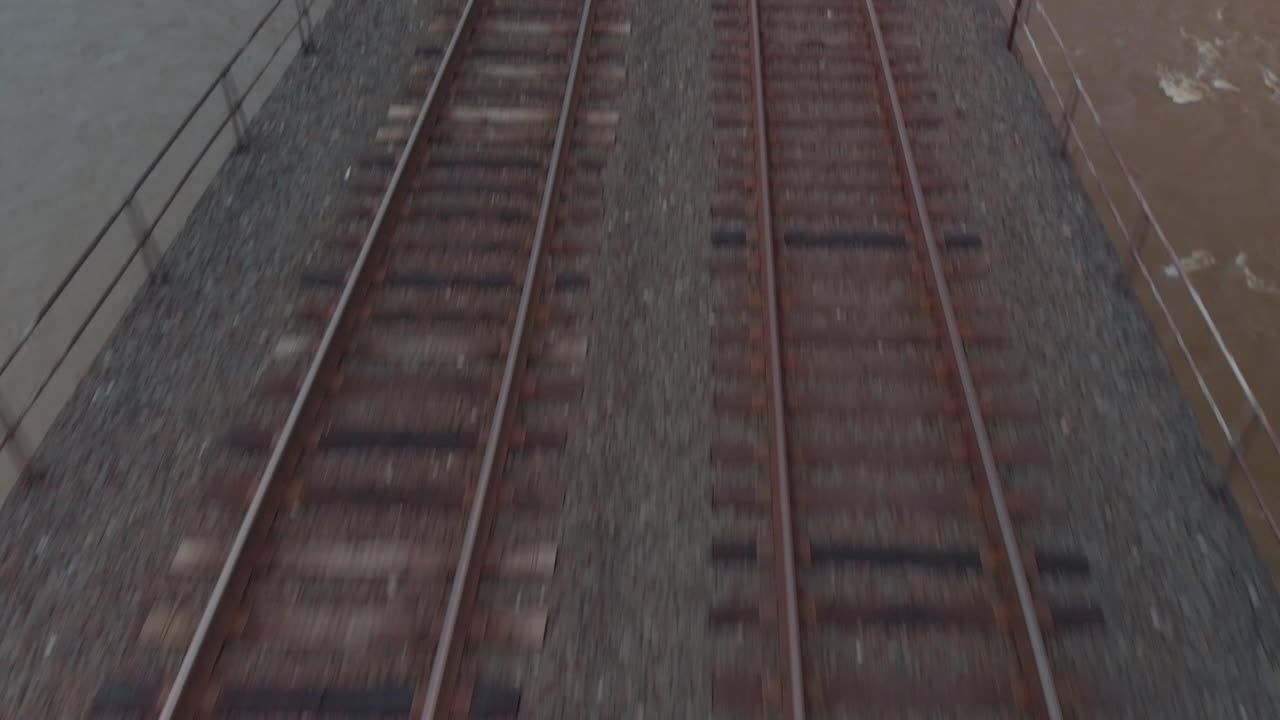 Close up on railroad tracks with rushing river below - Lancaster, Pennsylvania - Cold Color Grade