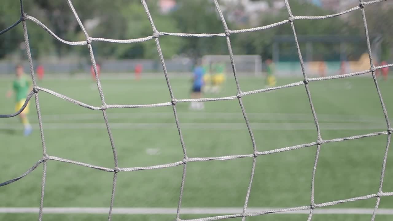 Fotbollsmatch genom ett nät