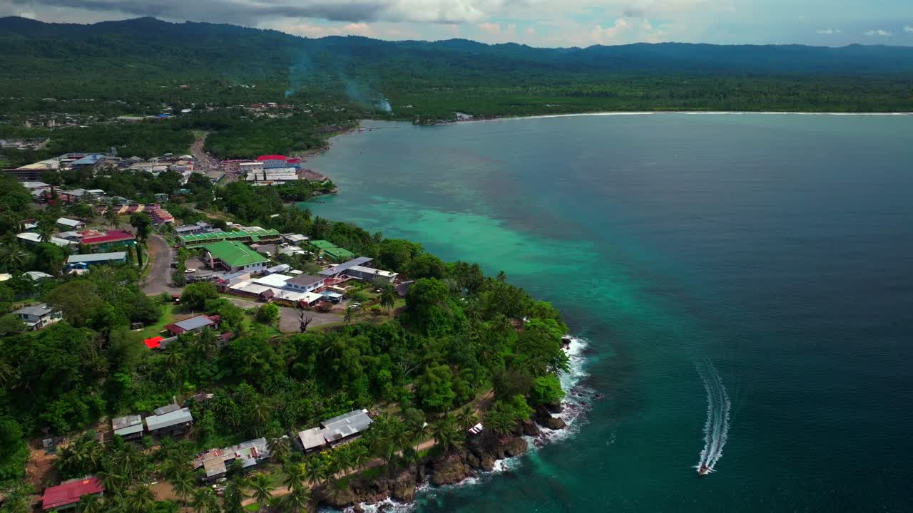 Power boat canoe driving Wewak costal town Dogreto Bay aerial drone Wewak Hill Papua New Guinea PNG East Sepik Region Province Boram road summer sunny morning dry season Bismark Sea forward pan up