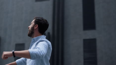 hombre barbudo feliz celebrando la victoria en el centro de la ciudad. hombre de negocios enérgico