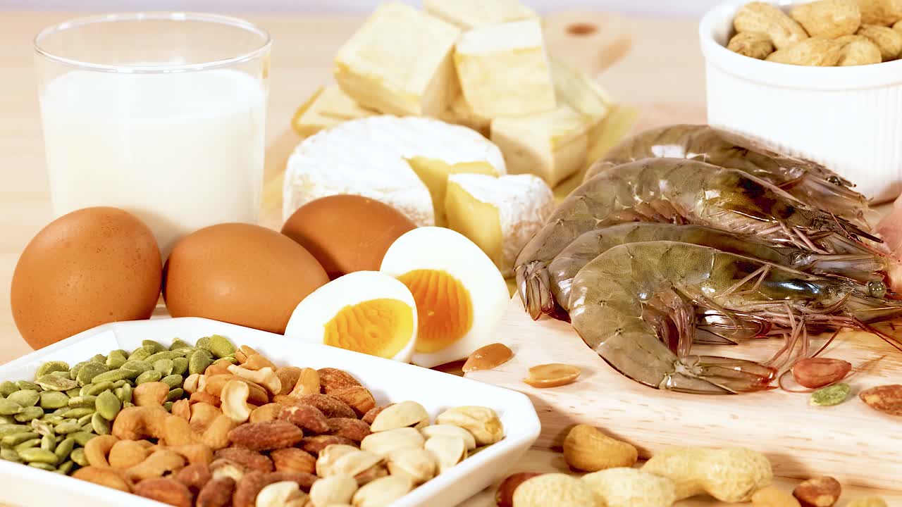 단백질이 풍부한 음식, 견과류, 해산물, 계란, 유제품 등이 밝고 자연적인 조명 속에서 생생하게 보여집니다.