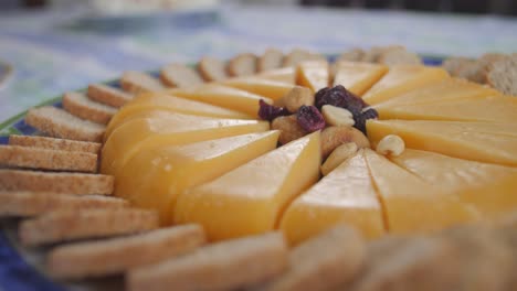 pieces of cheese and nuts and raisins on a plate on the table