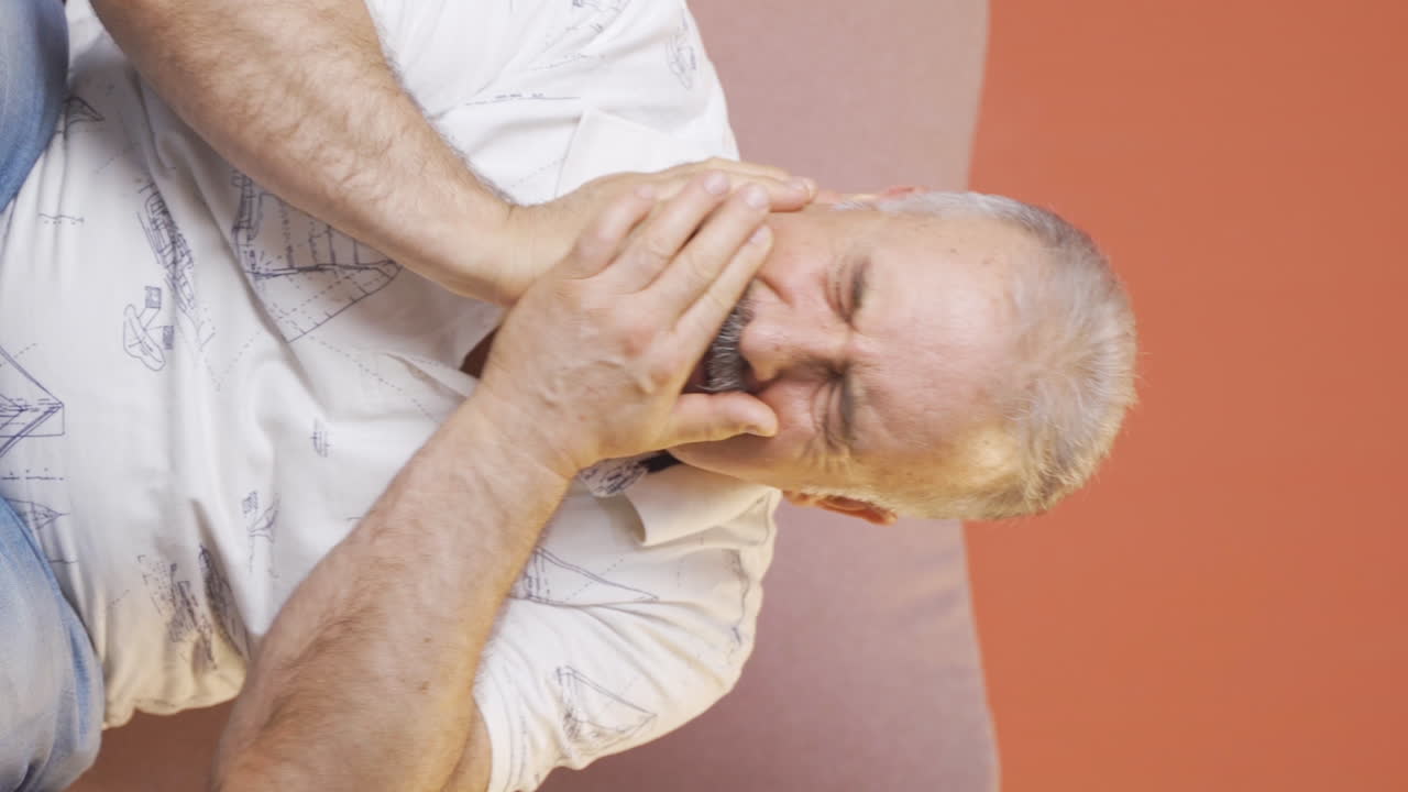 Vertikal video av gammel mann med tannpine