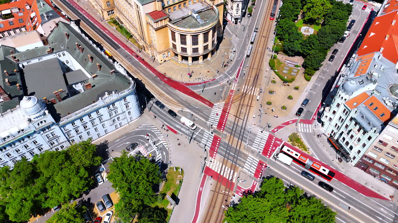People walk by the crossroads in the modern city. Old-style buildings surround the roads. Top view on modern Bratislava, Slovakia.