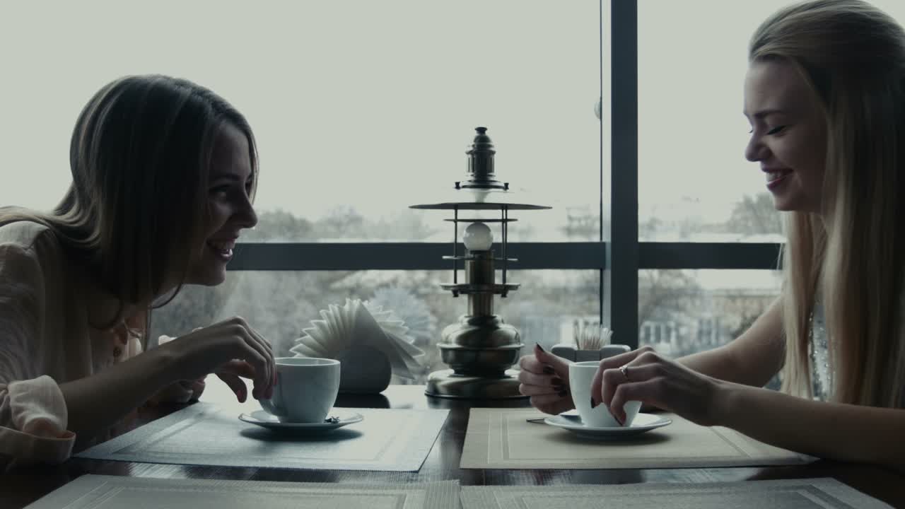 Two Girlfriends Drink Coffee