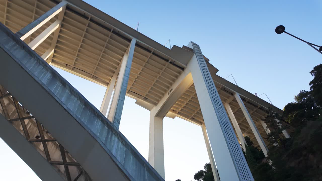 Arrábida Bridge seen from a low angle with blue sky background and clean architectural lines