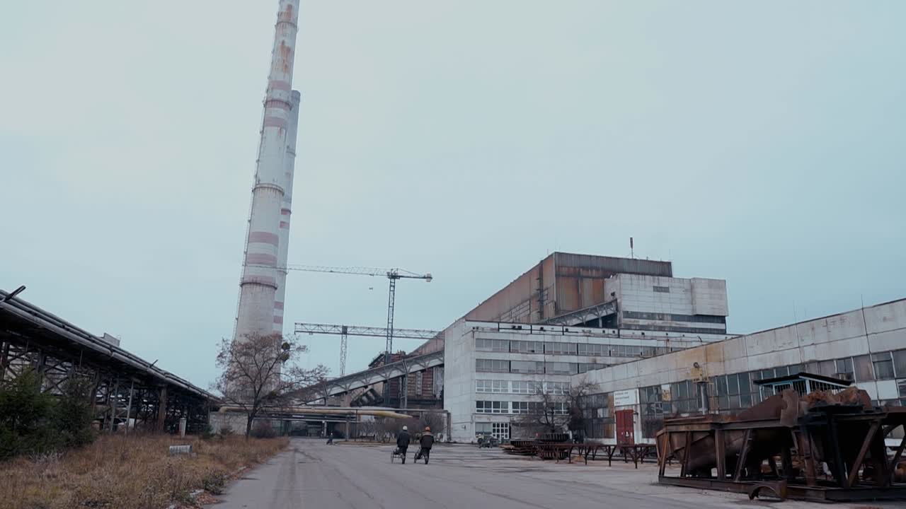 Territory and concrete buildings with pipes of an old post-Soviet coal-fired power plant. Iron rusty structures. Environmental pollution