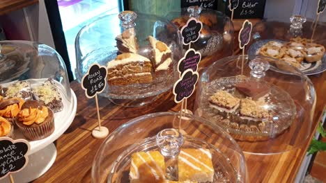 a beautiful selection of delicious tasty homemade cakes, cupcakes, slices and other sugary treats displayed on counter of local cafe