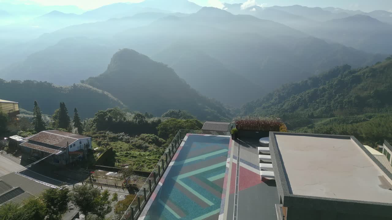 vista aérea de un hotel de lujo por la mañana con vistas a la piscina infinita y las montañas alishan